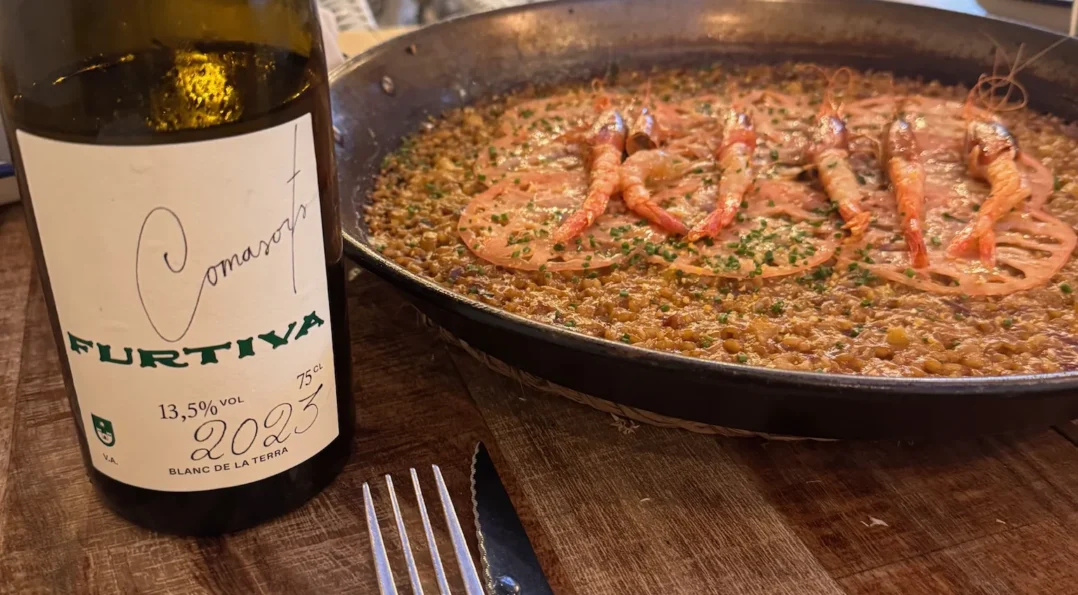 Arroz con gambas y vino blanco del Penedès servido en un restaurante de Sitges