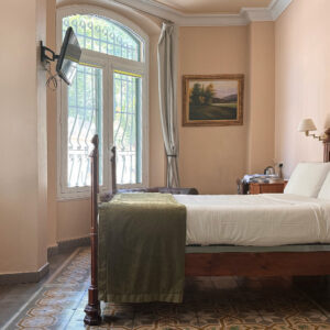 Habitación doble planta baja del Hotel Noucentista con mobiliario antiguo y suelo de mosaico