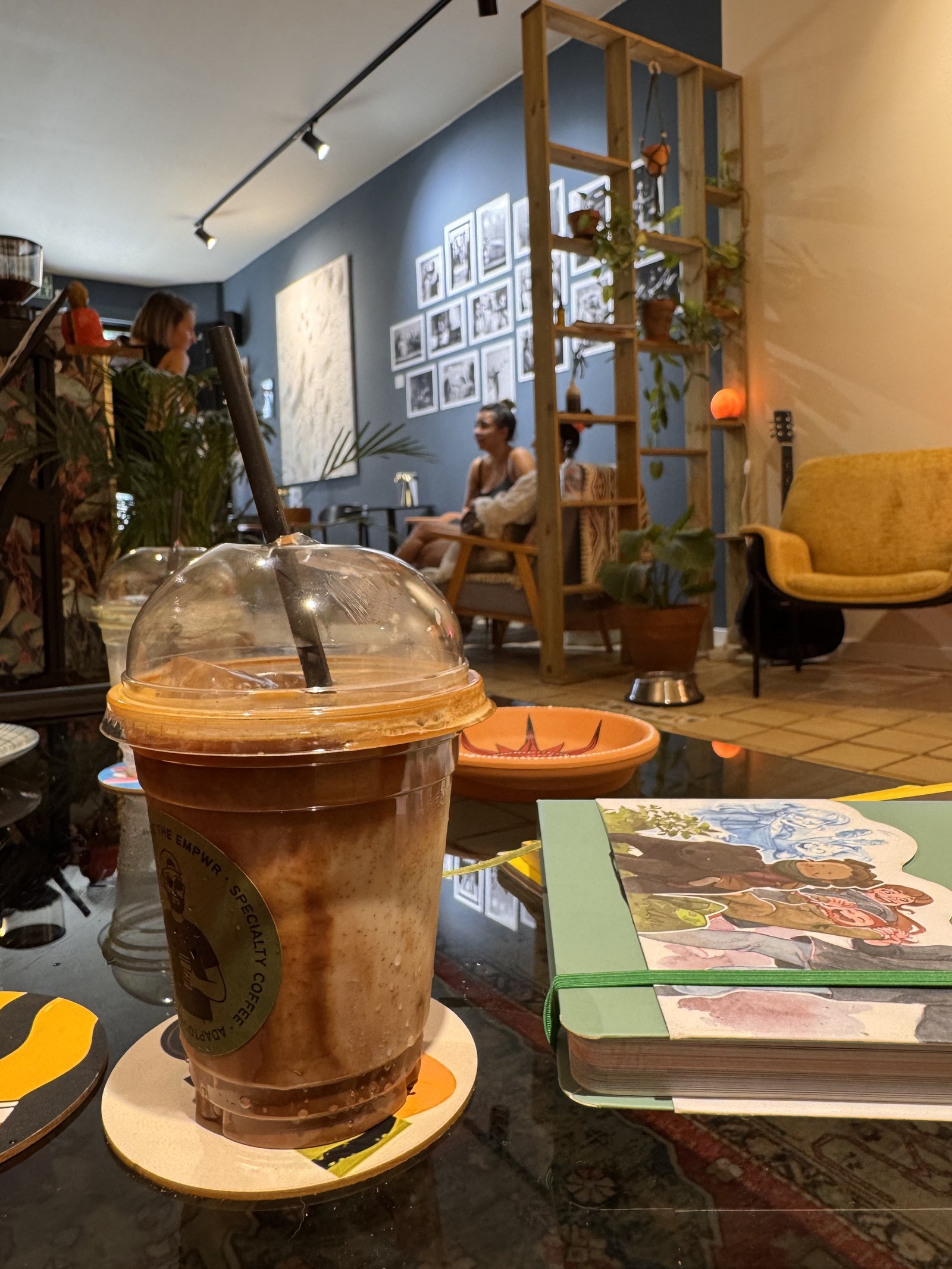 Café Aerocano con hielo junto a un cuaderno de bocetos en la cafetería de coworking The EMPWR en Sitges