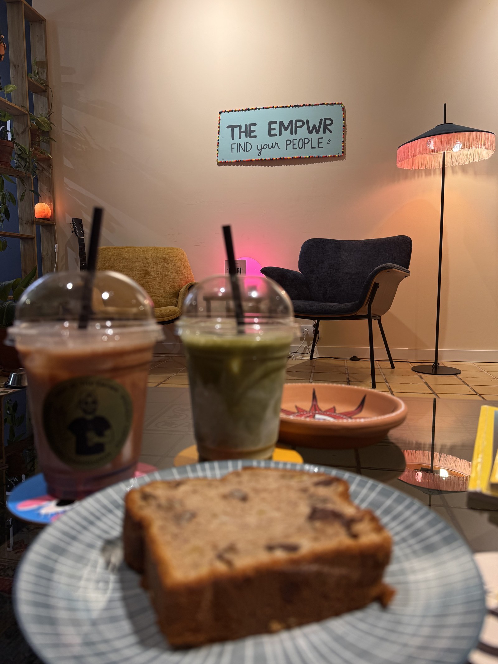 Dos bebidas adaptogénicas con hielo y una porción de pastel en la cafetería de coworking The EMPWR en Sitges