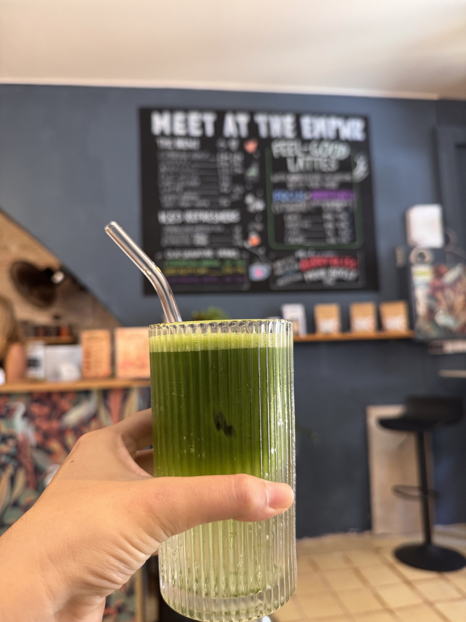 Matcha ceremonial alto delante del menú de lattes reconfortantes en The EMPWR en Sitges