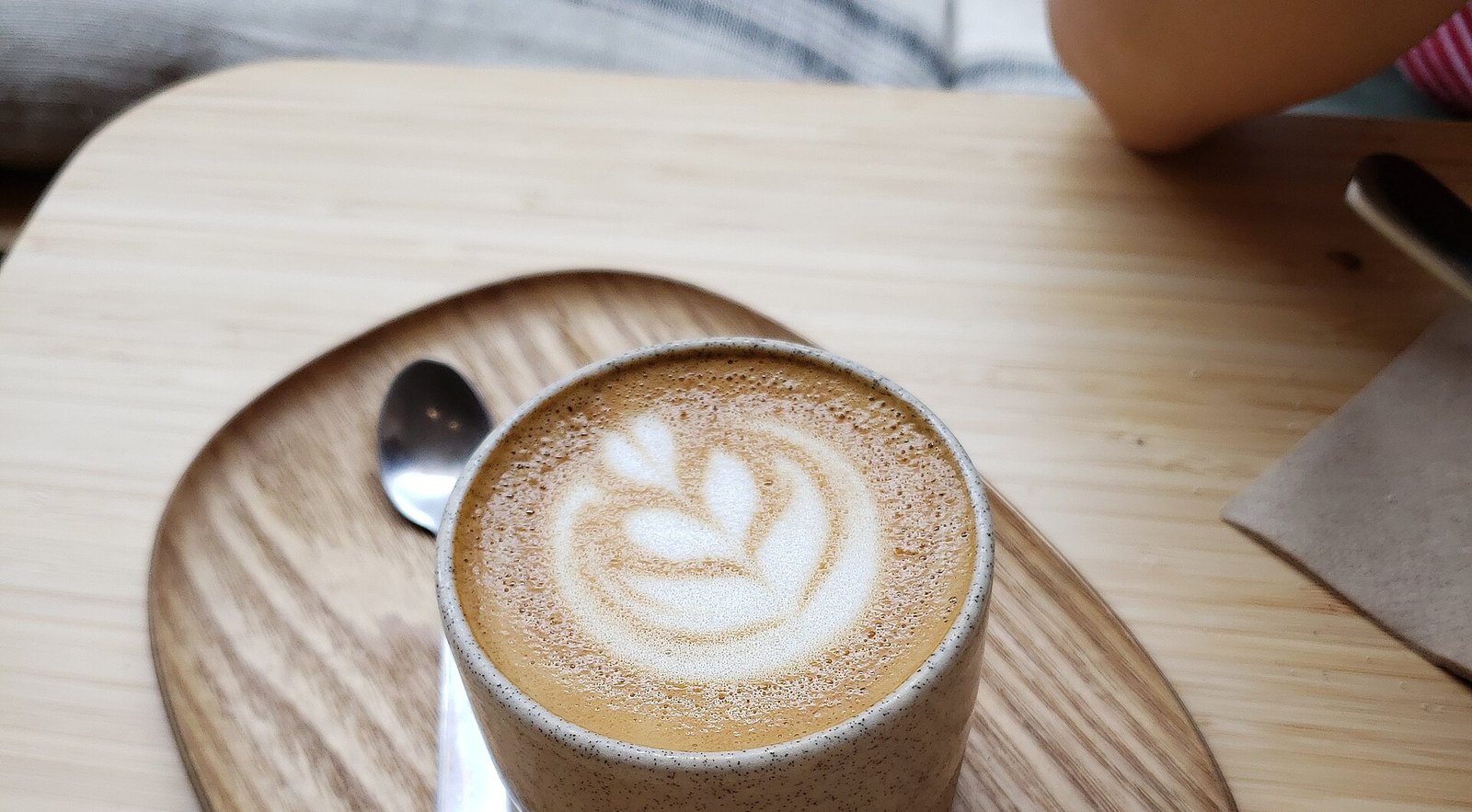 Taza de cortado servida en la barra de una cafetería de Sitges por la mañana