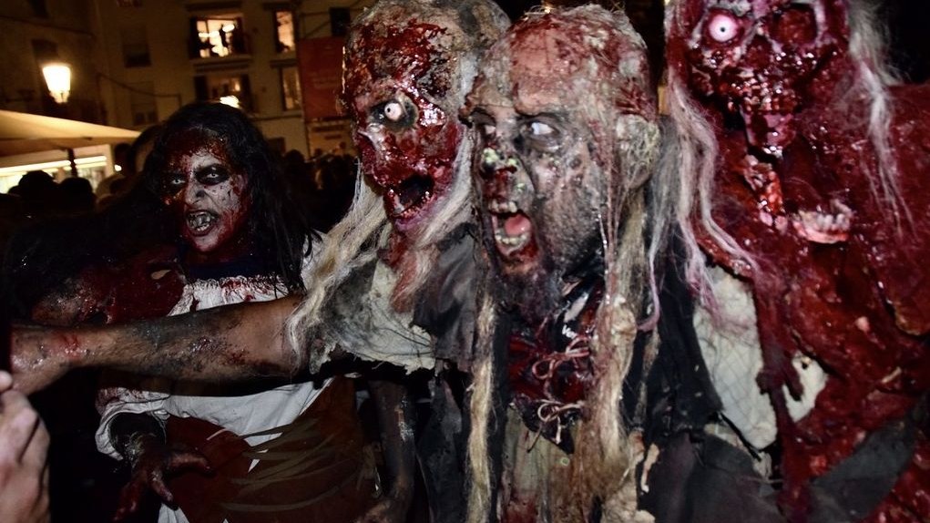 Grupo de figurantes maquillados de zombi por la noche durante el Festival de Sitges
