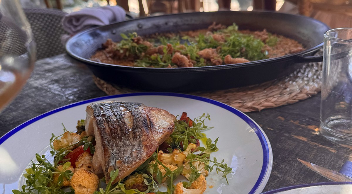 Terraza de un restaurante de Sitges con pescado a la plancha y arròs a la sitgetana para compartir