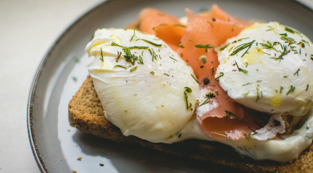 Nahaufnahme von pochierten Eiern und Lachstoast für einen Brunch in Sitges
