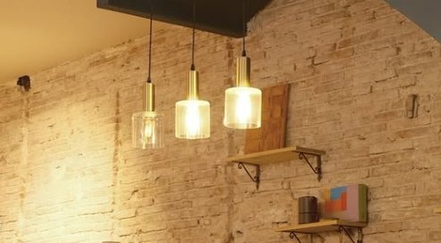Inside The EMPWR coworking cafe in Sitges, exposed brick wall and warm pendant lights